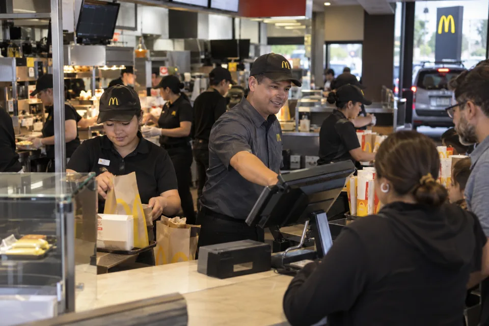 Busy McDonald’s restaurant where franchise employees serve customers beneath Golden Arches branding