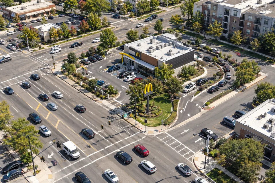 Aerial view of a McDonald’s restaurant on a busy corner with a drive-through and surrounding traffic